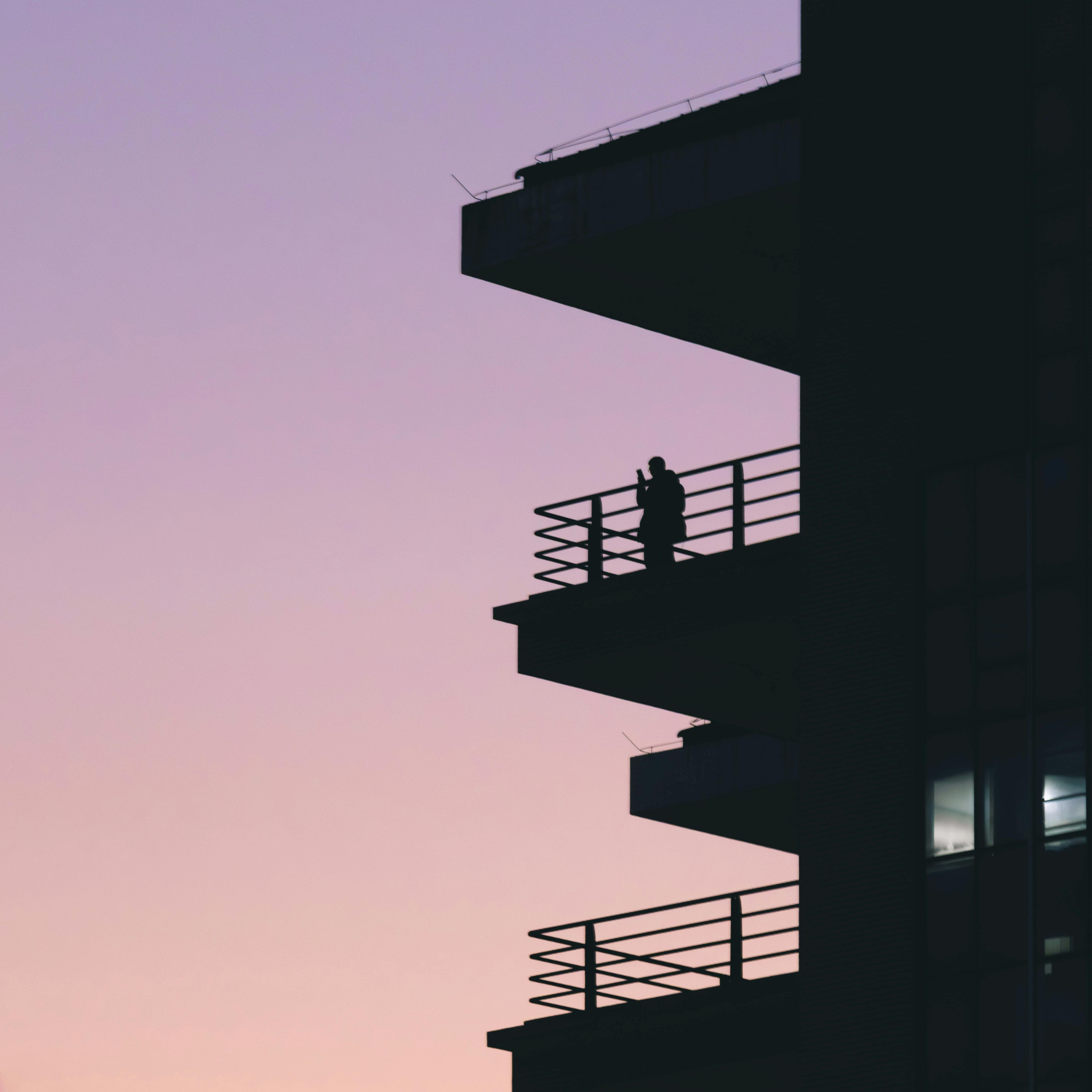 couple on a boutique hotel balcony overlooking a Mediterranean old town at sunset